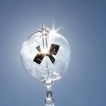 Orologio solare decorativo in vetro con riflessi di luce e dettagli metallici, perfetto come oggetto scientifico e decorativo per ambienti moderni e studi di design.