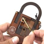 Dispositivo di sicurezza scientifico in legno con meccanismo di blocco e chiave, ideale come decorazione o oggetto da collezione ispirato a strumenti scientifici storici.