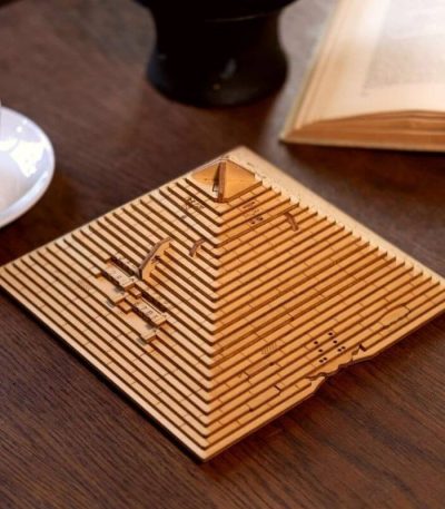 Modello di piramide in legno con dettagli geometrici, perfetto come decorazione scientifica o oggetto da collezione.