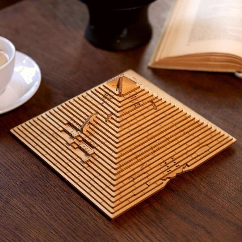 Modello di piramide in legno con dettagli geometrici, perfetto come decorazione scientifica o oggetto da collezione.