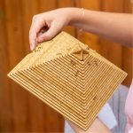 Modello 3D in legno con piramide, oggetto decorativo e scientifico, ideale per esposizioni e studi.