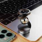 Oggetto scientifico in metallo e vetro su tastiera di laptop, decorazione moderna e tecnologica.