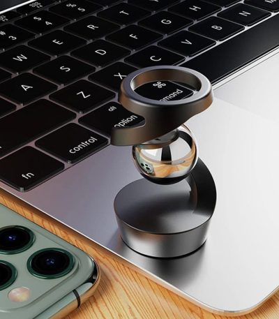 Oggetto scientifico in metallo e vetro su tastiera di laptop, decorazione moderna e tecnologica.