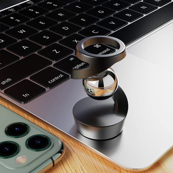 Oggetto scientifico in metallo e vetro su tastiera di laptop, decorazione moderna e tecnologica.