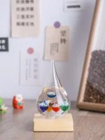 Vaso di vetro con liquidi colorati e sfere galleggianti, decorazione scientifica elegante e moderna per ambienti di studio o ufficio.