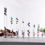 Vasi di vetro con sfere colorate e liquidi, decorazioni scientifiche eleganti e moderne per ambienti domestici o da ufficio.