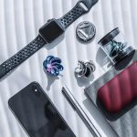 Orologio smart con cinturino perforato, accessori scientifici come campioni di cristalli e strumenti di laboratorio, e gadget tecnologici moderni.