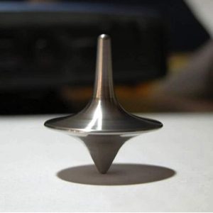 Tornado di metallo in equilibrio su una superficie, con ombra visibile, simbolo di equilibrio e precisione scientifica.