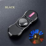 Spinner antistress nero con luci LED e pulsante rosa, ideale come decorazione scientifica o oggetto da scrivania, perfetto per rilassarsi e decorare ambienti moderni.