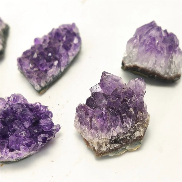 Quattro cristalli di ametista con sfumature viola, ideali come decorazioni scientifiche o oggetti da collezione, perfetti per appassionati di mineralogia e decorazioni originali.