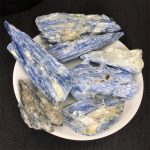 Pietre di kyanite blu e bianca, perfette per decorazioni scientifiche e collezioni, presentate su un piatto bianco.