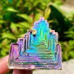Cristallo iridescente a forma di piramide con riflessi colorati, perfetto come decorazione scientifica o oggetto da collezione.