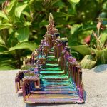 Piramide di cristallo iridescente con riflessi colorati, decorazione scientifica elegante e moderna, perfetta per appassionati di scienza e design innovativo.