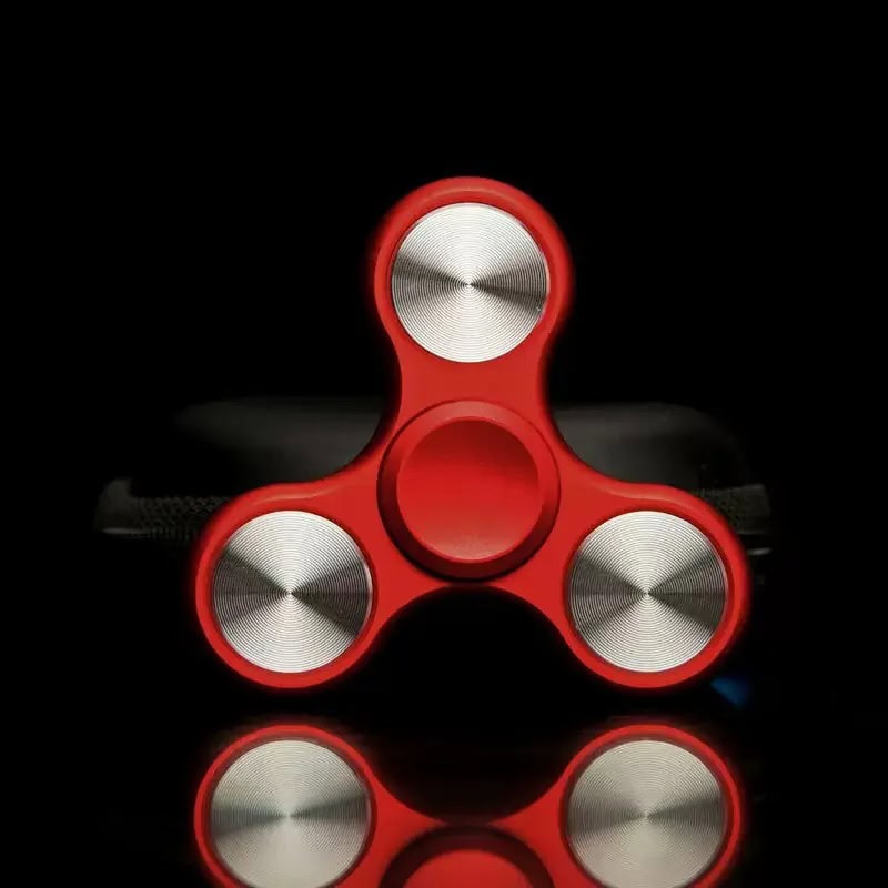 Fidget spinner rosso in metallo e plastica, oggetto antistress per rilassarsi e migliorare la concentrazione, ideale come decorazione scientifica moderna.