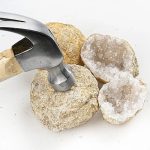 Pietre geode con cristalli di quarzo, accompagnate da martello da geologo, perfette come decorazioni scientifiche e oggetti da collezione.