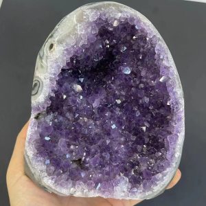 Geode di ametista naturale con cristalli viola intensi, perfetto come decorazione scientifica o oggetto da collezione.