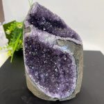 Geode di ametista naturale con cristalli viola lucenti, perfetta come decorazione scientifica o oggetto da collezione.