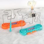 Gioco scientifico con fili metallici e base colorata, ideale per stimolare la creatività e l'apprendimento della fisica nei bambini.