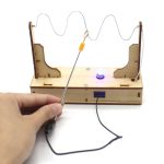Modello di circuito elettrico con filo, LED e supporto in legno, ideale per attività educative e decorazioni scientifiche.