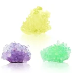 Cristalli di sale colorati in tonalità giallo, viola e verde, ideali come decorazioni scientifiche e oggetti da collezione. Perfetti per appassionati di scienza e decorazioni originali.