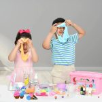 Due bambini che giocano con slime colorato, creando forme divertenti e fantasiose, in un ambiente luminoso e allegro.