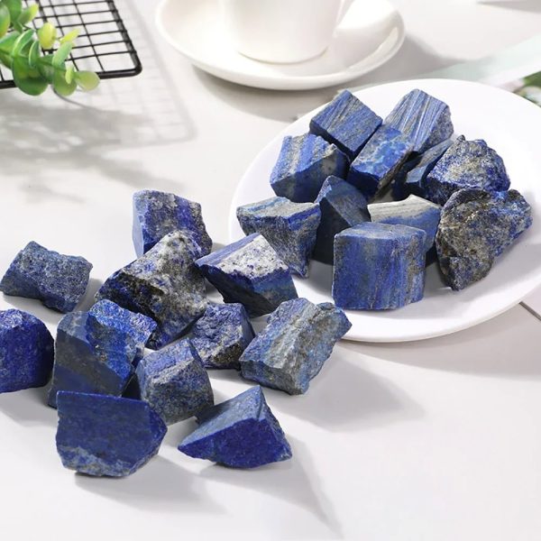 Pietre di lapislazzuli blu, perfette per decorazioni e progetti scientifici, disposte su un piatto bianco con sfondo luminoso.