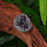 Pendente decorativo con cristallo iridescente su tronco di legno, ideale come oggetto di decorazione scientifica o da collezione.