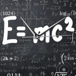 Orologio con simbolo E=mc² e formule scientifiche su lavagna nera, rappresentando la fisica e la scienza.