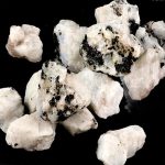 Gruppo di pietre di quarzo con inclusioni nere, perfette come decorazioni scientifiche o oggetti da collezione, con superficie cristallina e dettagli unici.