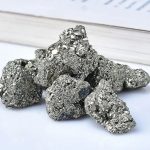 Pietre di pirite naturale con superficie scintillante e struttura cristallina, ideali come decorazioni scientifiche o oggetti da collezione.