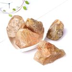 Quattro cristalli di salgemma naturale in diverse tonalità di rosa e marrone, disposti su una superficie bianca. Perfetti come decorazioni scientifiche o oggetti di design.