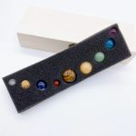 Palline di vetro colorate in scatola di presentazione, perfette come decorazioni scientifiche o oggetti da collezione, con vari colori e motivi.