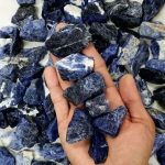 Pietre di sodalite blu scuro con venature bianche, ideali per decorazioni scientifiche e collezioni mineralogiche.