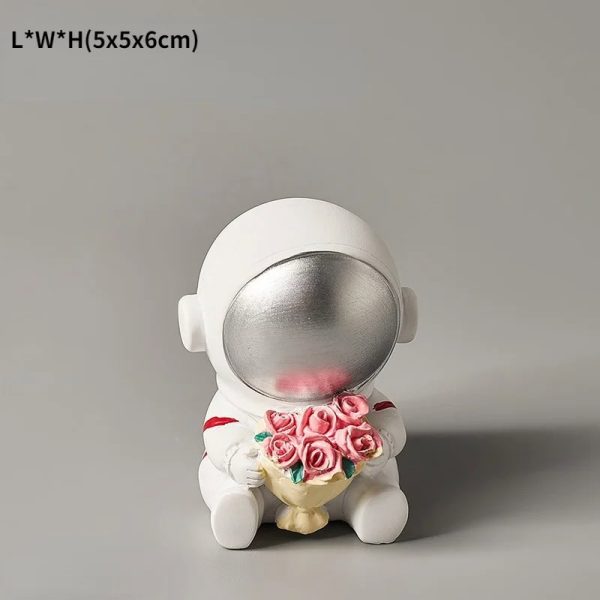 Decorazione da scrivania a forma di astronauta con casco argentato e bouquet di rose rosa, perfetta come regalo o decorazione scientifica.