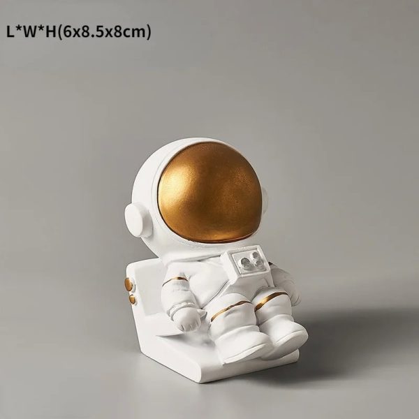 Oggetto decorativo a forma di astronauta in resina bianca con casco dorato, ideale come decorazione scientifica o da collezione. Perfetto per appassionati di spazio e scienza.