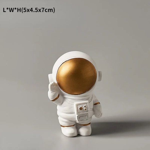 Statua di un astronauta in stile decorativo con casco dorato lucido, perfetta come oggetto da collezione o decorazione scientifica moderna.