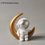 Decorazione astronauta in stile cartone animato con luna dorata, perfetta come oggetto decorativo scientifico per appassionati di spazio e astronomia.