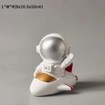 Decorazione scientifica di un astronauta in tuta spaziale su un razzo, ideale per appassionati di spazio e scienza, perfetta come oggetto decorativo per ambienti educativi o di intrattenimento.