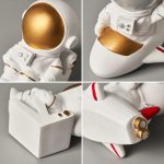 Decorazione da collezione di un astronauta in resina bianca con dettagli oro, perfetta come oggetto decorativo o regalo a tema spaziale.