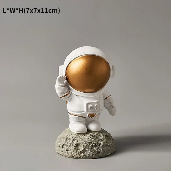 Figura di un astronauta in miniatura con casco dorato, vestito bianco, in piedi su una roccia, simbolo di esplorazione spaziale e curiosità scientifica.
