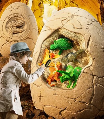 Bambino che interagisce con dinosauri giocattolo in una teca di roccia, decorazione scientifica per ambienti educativi e ludici.