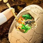 Uovo di dinosauro con figure di dinosauri colorate all'interno, perfetto come decorazione scientifica educativa e giocattolo per bambini appassionati di paleontologia.