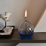 Vaso di vetro con fiamma accesa e decorazione scientifica, ideale per oggetti decorativi e scientifici. Perfetto per ambienti moderni e studi scientifici, combinando estetica e funzionalità.