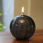Oggetto decorativo a forma di sfera in vetro con fiamma accesa, ideale come decorazione scientifica o da tavolo. Design elegante e moderno, perfetto per ambienti sofisticati.