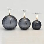 Vasi decorativi a forma di candela con fiamma in vetro scuro, disponibili in tre dimensioni: 10cm, 8cm e 6cm, perfetti per decorazioni scientifiche e ambienti eleganti.
