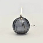 Palla di vetro decorativa con candela accesa, fiammella alta 10cm, ideale come oggetto decorativo o da collezione scientifica.