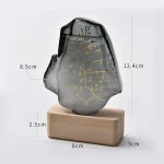 Astrolabio in pietra con incisioni dorate, simboli astronomici e linee di misurazione, montato su base di legno, perfetto come decorazione scientifica e oggetto da collezione.
