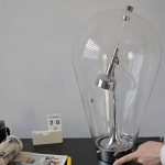 Lampada scientifica decorativa in vetro con elementi metallici, perfetta come oggetto di design e decorazione ispirata alla scienza.