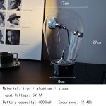 Lampada decorativa a energia cinetica con base in metallo, vetro e alluminio, altezza 27cm, larghezza 8cm, profondità 17cm, perfetta come decorazione scientifica moderna.