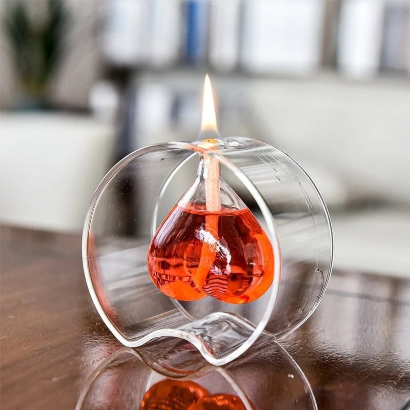 Vaso di vetro con candela a forma di goccia di liquido rosso Vaso di vetro trasparente con candela accesa a forma di goccia di liquido rosso, decorazione scientifica elegante e moderna.